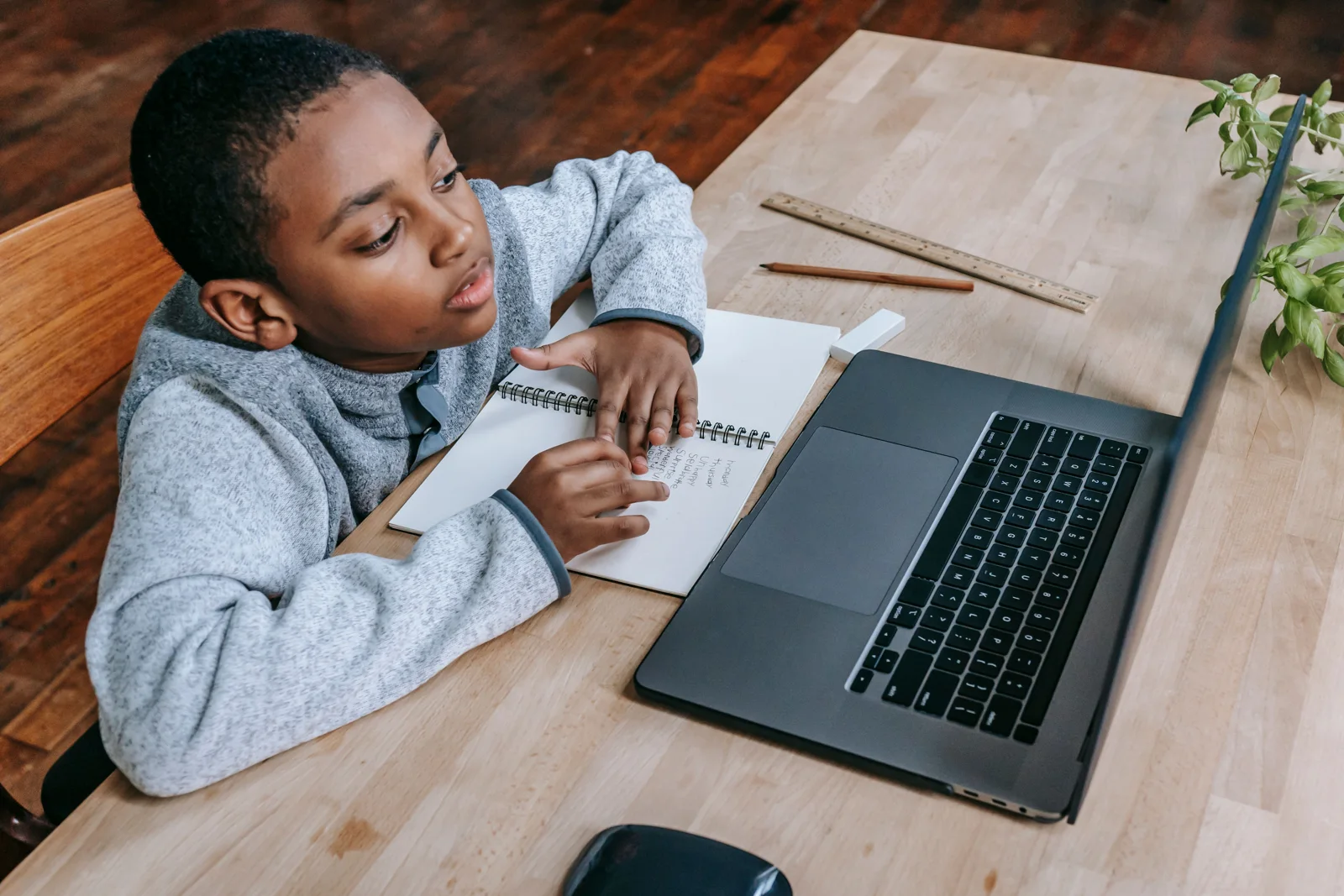 Learner studying with a notebook and laptop